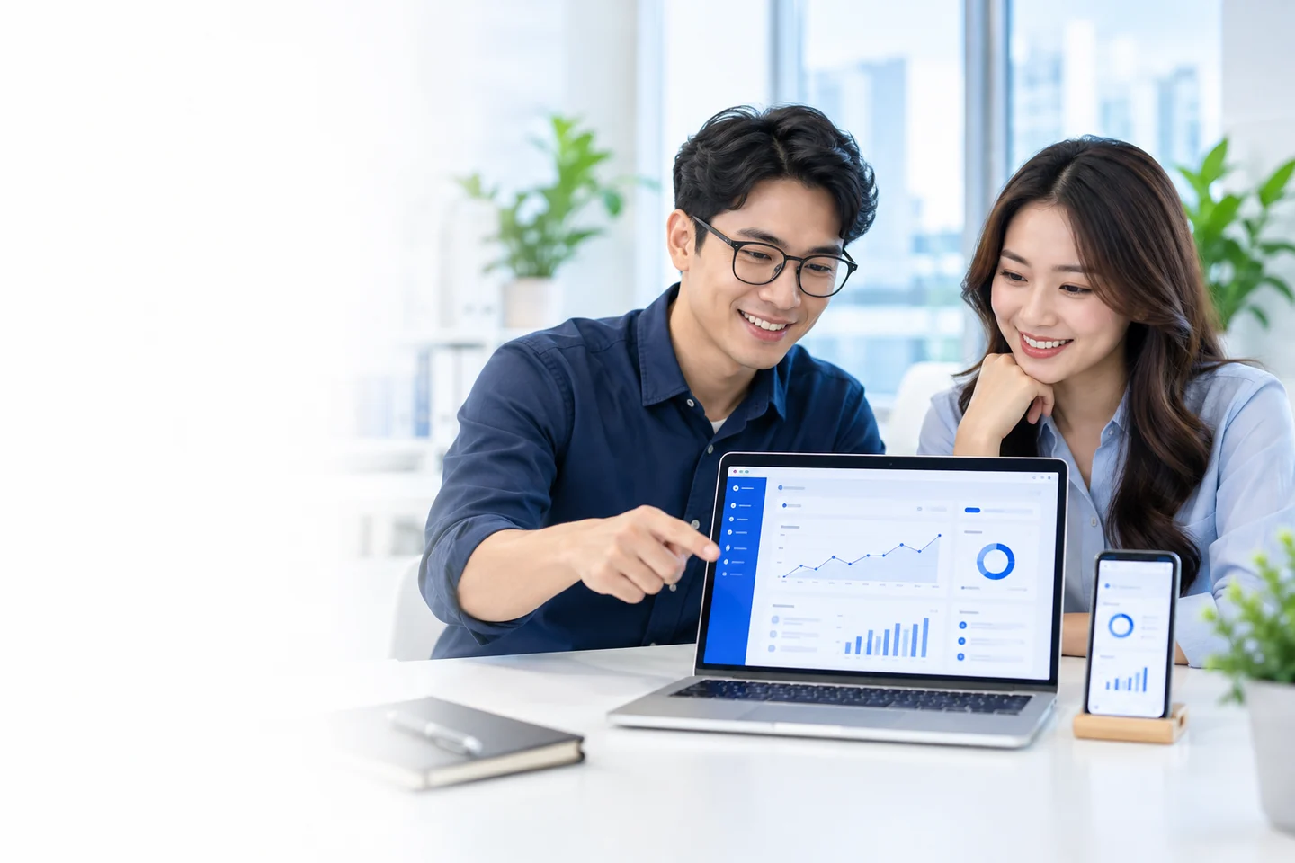 Tim berdiskusi dengan aplikasi bisnis di laptop dan ponsel